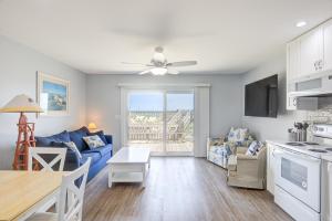 a living room with a blue couch and a table at Topsail Villa 24 in North Topsail Beach