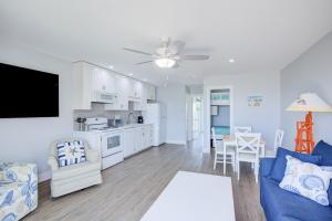 a living room with a blue couch and a kitchen at Topsail Villa 24 in North Topsail Beach +15 photos
