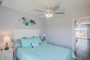 a bedroom with a blue bed and a ceiling fan at Topsail Villa 24 in North Topsail Beach