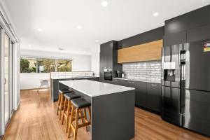 a kitchen with a large island and a black refrigerator at La Calma in San Remo