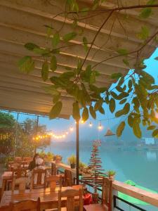 a restaurant with tables and a view of the water at Funny Monkeys Homestay in Phong Nha