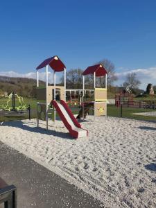 un parque infantil con un tobogán en la arena en Le P'tit Torceen proche de Dieppe par Com'en Normandie en Torcy-le-Petit