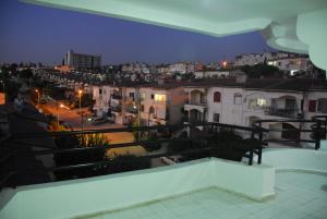 a balcony with a view of a city at night at Ozgun Apart Hotel in Kusadası