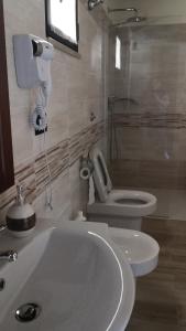 La salle de bains est pourvue d'un lavabo blanc et de toilettes. dans l'établissement Camera matrimoniale 1 per vacanza al mare VILLA FRANCA, à Cariati