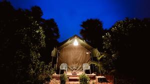 une tente avec 2 chaises devant elle la nuit dans l'établissement Beyond Community, à Auroville