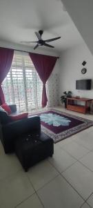 uma sala de estar com um sofá e uma ventoinha de tecto em HOMESTAY HAIKALHAIDAR em Rantau Panjang