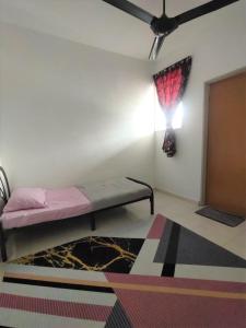 a bedroom with a bed and a ceiling fan at HOMESTAY HAIKALHAIDAR in Rantau Panjang