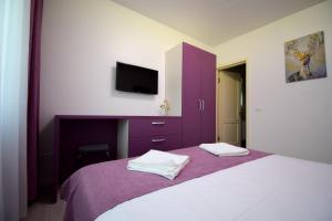 a bedroom with a purple cabinet and a bed at Pensiunea Happy Day Horezu in Horezu