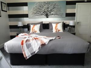 een slaapkamer met een groot bed en een gestreepte muur bij Copperbeech B&B in Yoxford +37 foto's