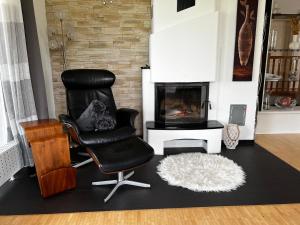 a black chair in a living room with a fireplace at Exclusive High-quality Apartment Spessart in Marktheidenfeld