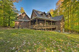 a log home with a large deck in the woods at Dog-Friendly Gaylord Retreat Less Than 8 Mi to Town! in Gaylord