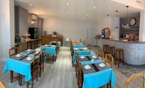 un restaurant avec des tables et des chaises bleues et un comptoir dans l'établissement Logis Hotel du Midi, à Salon-de-Provence