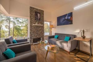 a living room with two couches and a fireplace at StayVista at Pines & Fir - Sprawling Gardens with Seating and Swings in Lansdowne