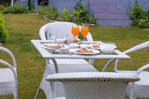 una mesa con platos de comida y vasos de zumo de naranja en StayVista at Pines & Fir - Sprawling Gardens with Seating and Swings, en Lansdowne