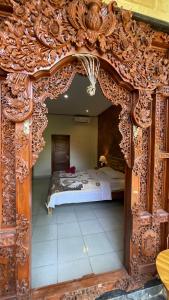 una camera da letto con letto e struttura in legno decorata di Satria Bungalow a Uluwatu