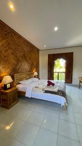 een slaapkamer met een groot bed in een kamer bij Satria Bungalow in Uluwatu