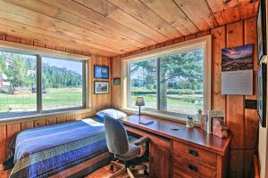 a bedroom with a desk and a bed and windows at Family Home with Stunning River and Mountain View in Priest River