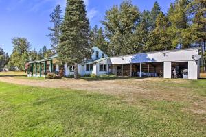 a white house with a large yard at Family Home with Stunning River and Mountain View in Priest River