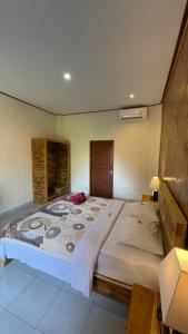 1 dormitorio con 1 cama grande en una habitación en Satria Bungalow, en Uluwatu