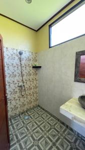 a bathroom with a shower and a sink at Satria Bungalow in Uluwatu