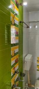 a bathroom with a toilet and a green wall at Hotel Shri Sai Darshan in Shirdi