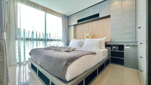 a large bed in a room with a large window at Citygate Kamala Resort and Residence in Kamala Beach