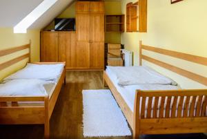 a room with two beds and wooden cabinets at U Teodora in Bratislava