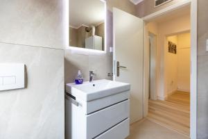 ein weißes Badezimmer mit einem Waschbecken und einem Spiegel in der Unterkunft Apartement in Zell in Zell am Main