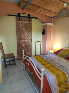 1 dormitorio con 1 cama, 1 silla y 1 puerta en Villas en chanay, en Dagneux