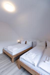 2 Betten in einem Zimmer mit weißen Wänden in der Unterkunft Apartement in Zell in Zell am Main