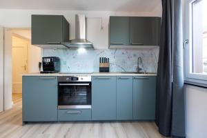 a kitchen with blue cabinets and a stove at Apartement in Zell in Zell am Main