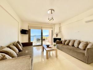 uma sala de estar com um sofá e uma mesa em Luxury Villa San George with private pool by DadoVillas em Nydri