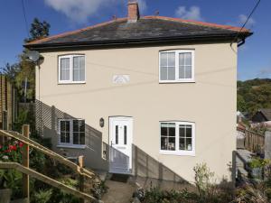 a white house with a fence in front of it at Pound Cottage in Lyme Regis