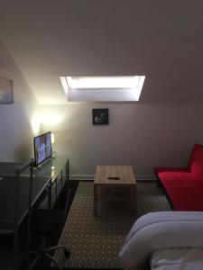 Habitación con cama, mesa y sofá en Victor Hugo 4 D et sa pizza offerte, en Aurillac