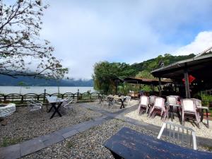 a group of chairs and tables next to a lake at The Freedom Huts in Pokhara
