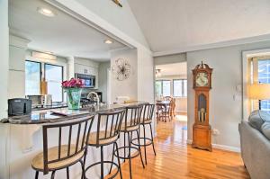 a kitchen and living room with a bar with stools at 2 Mi to South Cape Beach State Park Home with Yard! in Mashpee
