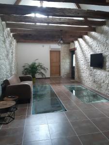 a living room with a pool in a stone wall at Moulin Clamens in Cavarc