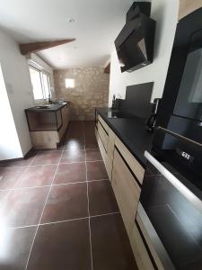 a kitchen with black counter tops and a tile floor at Moulin Clamens in Cavarc