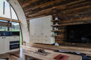 sala de estar con paredes de madera y TV grande en World's Only Skybarrel on edge of Extinct Volcano en Buninyong