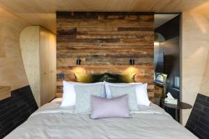 1 dormitorio con 1 cama con pared de madera en World's Only Skybarrel on edge of Extinct Volcano en Buninyong