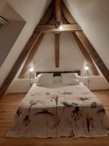a bedroom with a large bed in an attic at Moulin Clamens in Cavarc