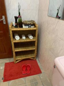 um par de sapatos vermelhos num tapete vermelho na casa de banho em Teresita Home em Nairobi