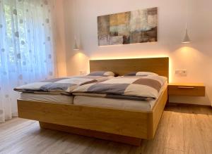um quarto com uma cama grande e uma cabeceira em madeira em Neu, zentral, sonnig, Garage inklusive em Merano