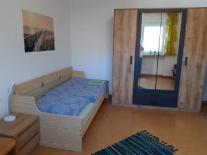 - une petite chambre avec un lit et une porte dans l'établissement Ferienwohnung im Seidlerhof mit Balkon und Garten, à Röhrnbach