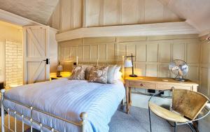 a bedroom with a bed and a desk and a chair at The Woolpack Inn in Coggeshall
