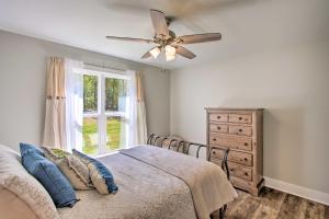 - une chambre avec un lit et un ventilateur de plafond dans l'établissement Cozy Counce Cabin with Fire Pit - Near Golfing!, à Counce