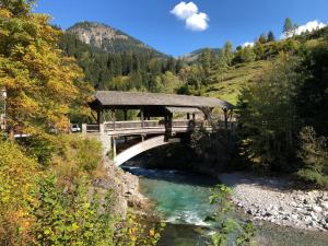 un pont sur une rivière à côté d'une montagne dans l'établissement Ferienwohnung Höhenrausch, à Bad Hindelang