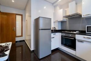 a kitchen with a stainless steel refrigerator and white cabinets at Racine Two bedroom flat near twin center in Casablanca +34 photos