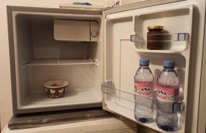 dos botellas de agua en un refrigerador abierto en Chambre d'hôte dans chalet près des pistes et aux départs de randonnées en Les Carroz d'Araches