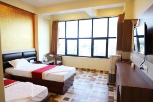 Habitación de hotel con 2 camas y ventana grande. en HOTEL PERFECT PLAZA, en Janakpur